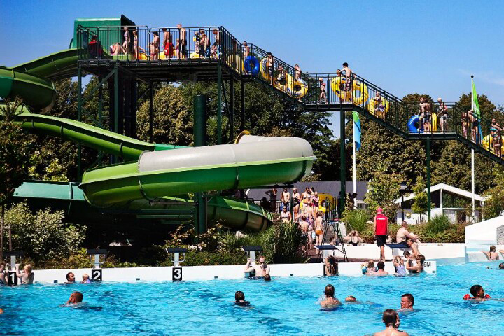 Brunnsbadets långa vattenrutchkana och fullt med badande människor.